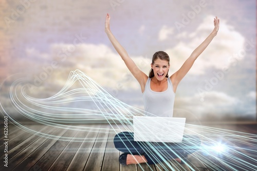 Cheering blonde using laptop with clouds