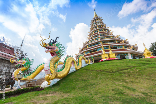 Double dragon statue with stupa on blue sky photo