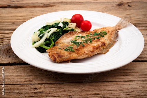 Photo Fried flounder with onion, cabbage and potato