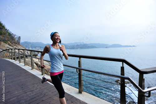 Fototapeta Naklejka Na Ścianę i Meble -  fitness woman running at seaside wooden bridge