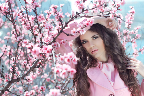 Portrait of Beautiful woman posing over Pink Spring Cherry bloss photo