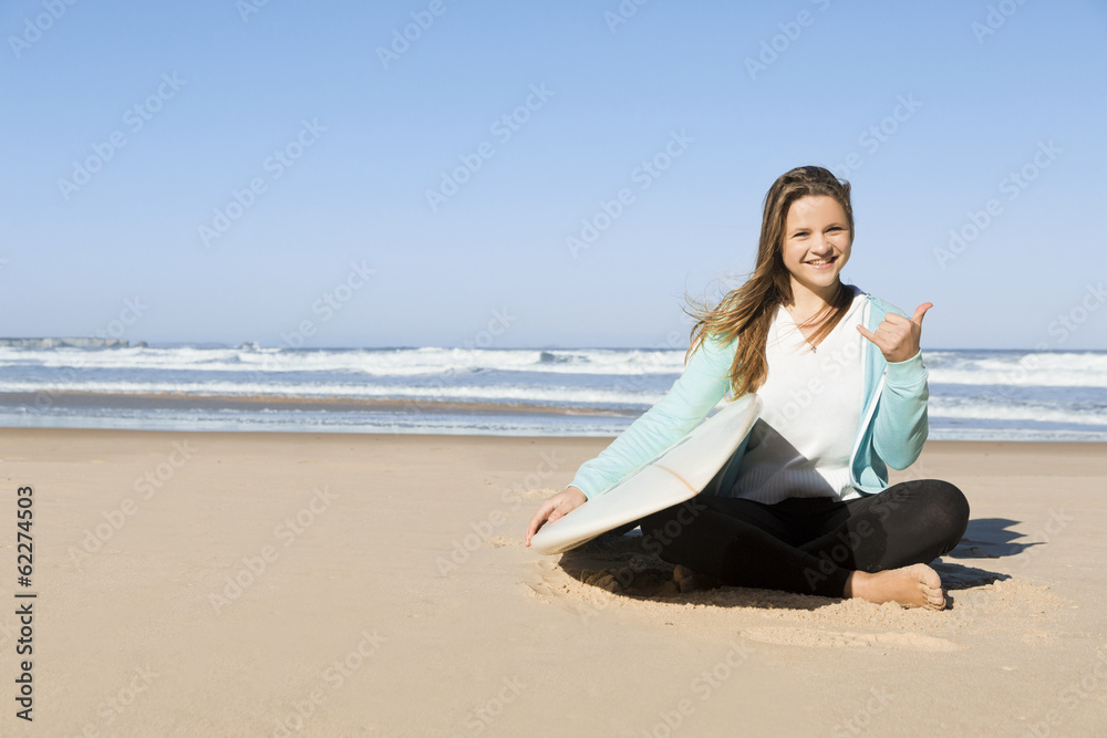Portrait of a teenage girl in the beach sitting on the sand 