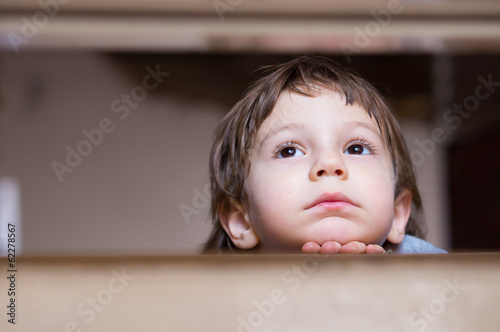 sad little boy thinking looking up