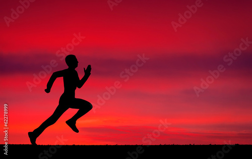 Silhouette of running man on sunset fiery background
