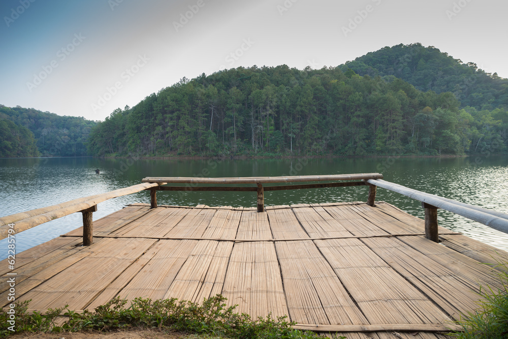 Pier in lake with mountain background.