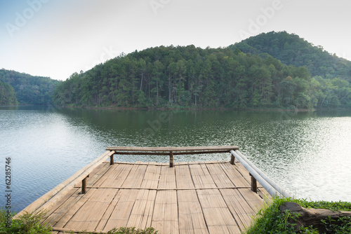 Pier in lake with mountain background. © anonpichit