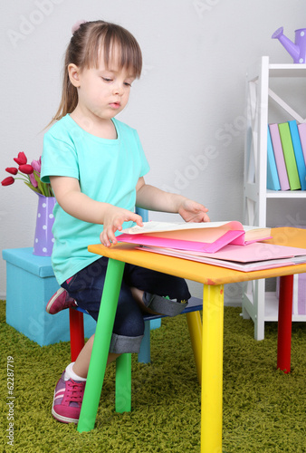 Little girl reads book sitt...