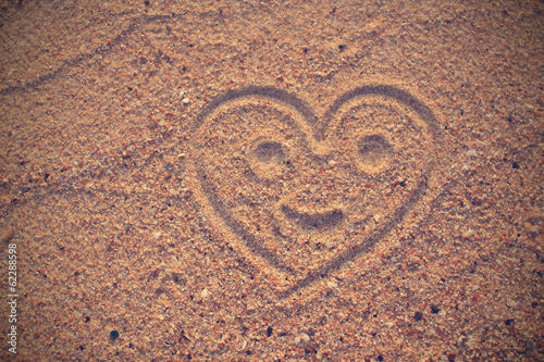 Heart shape drawn on beach sand in vintage style