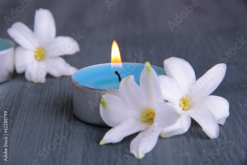 White hyacinth with candle on wooden background