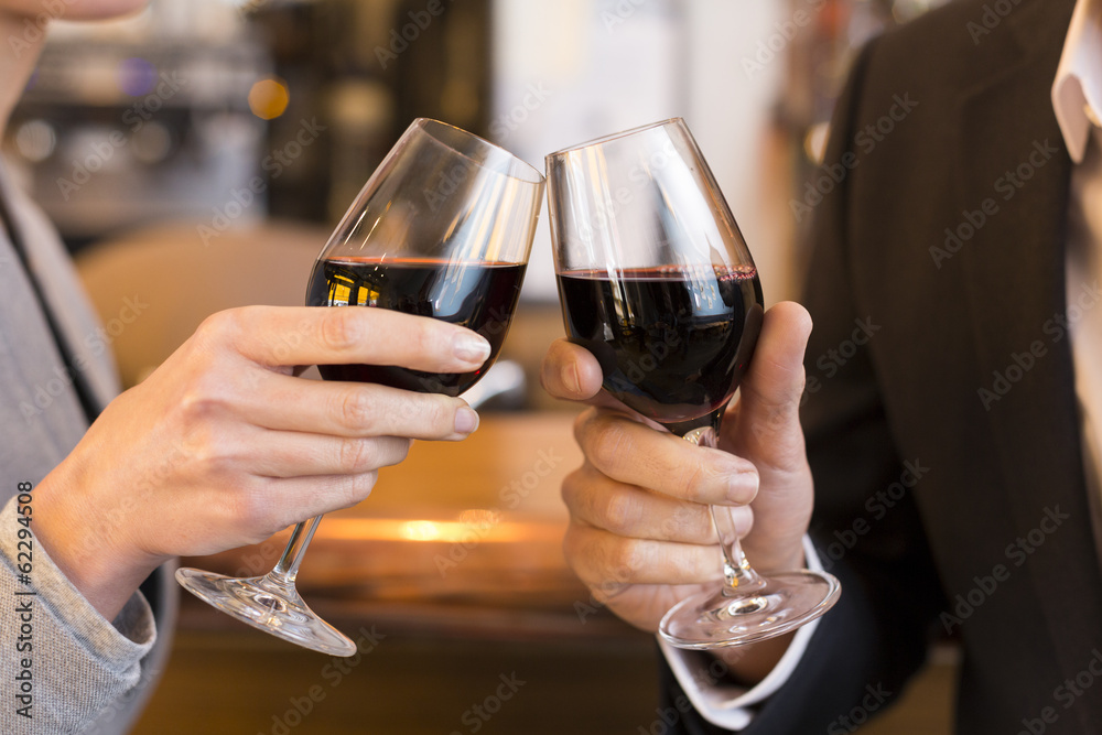 Close Up of Couple Toasting with red wine glass in restaurant