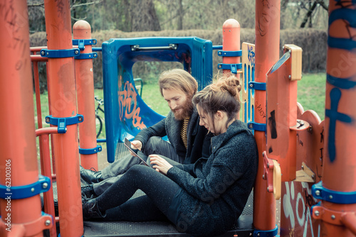 young modern stylish couple using tablet photo