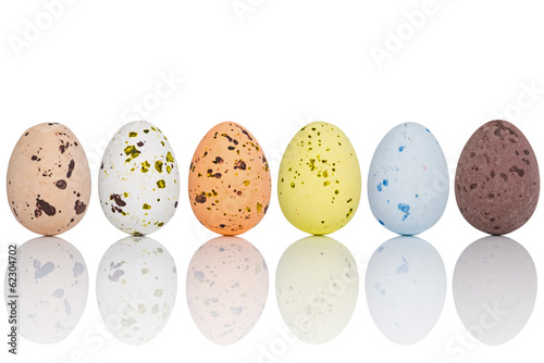 Candy covered Easter eggs in a line isolated