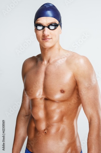 Young athletic man in swimming cap and googles