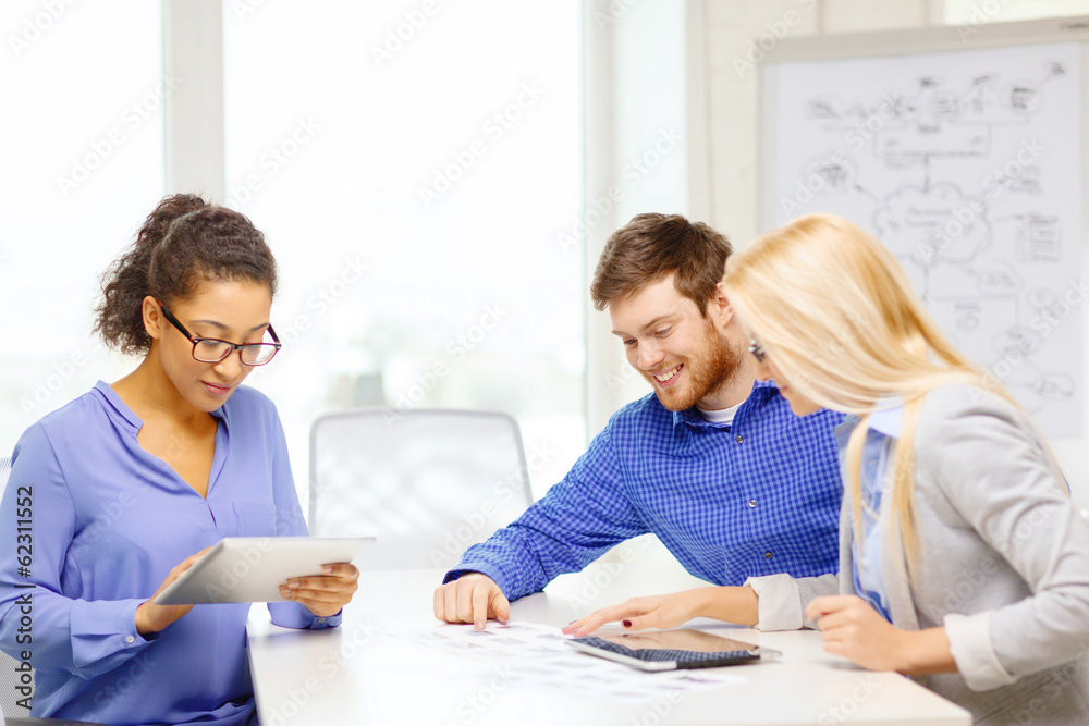 smiling team with table pc and papers working smiling team with table pc and papers working