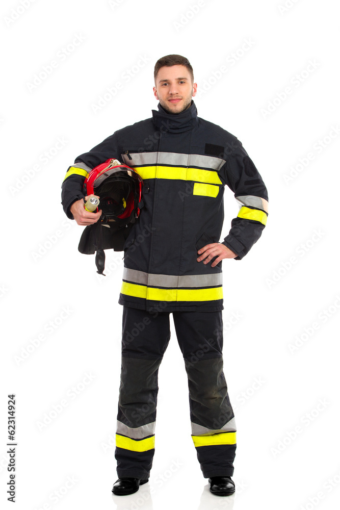 Firefighter posing with helmet under his arm Firefighter posing with helmet under his arm