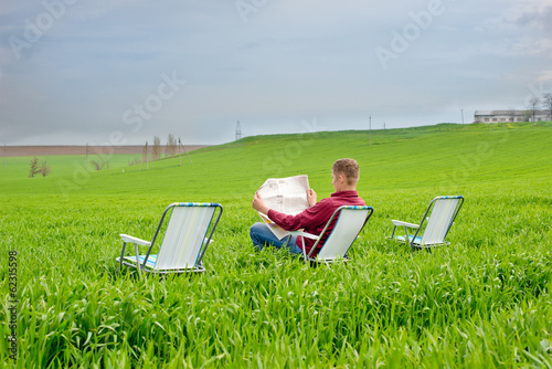 man reading a newspaper outdoors photo