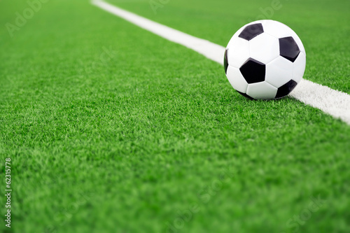 Traditional soccer ball on soccer field, green field sports background © Mariusz Blach