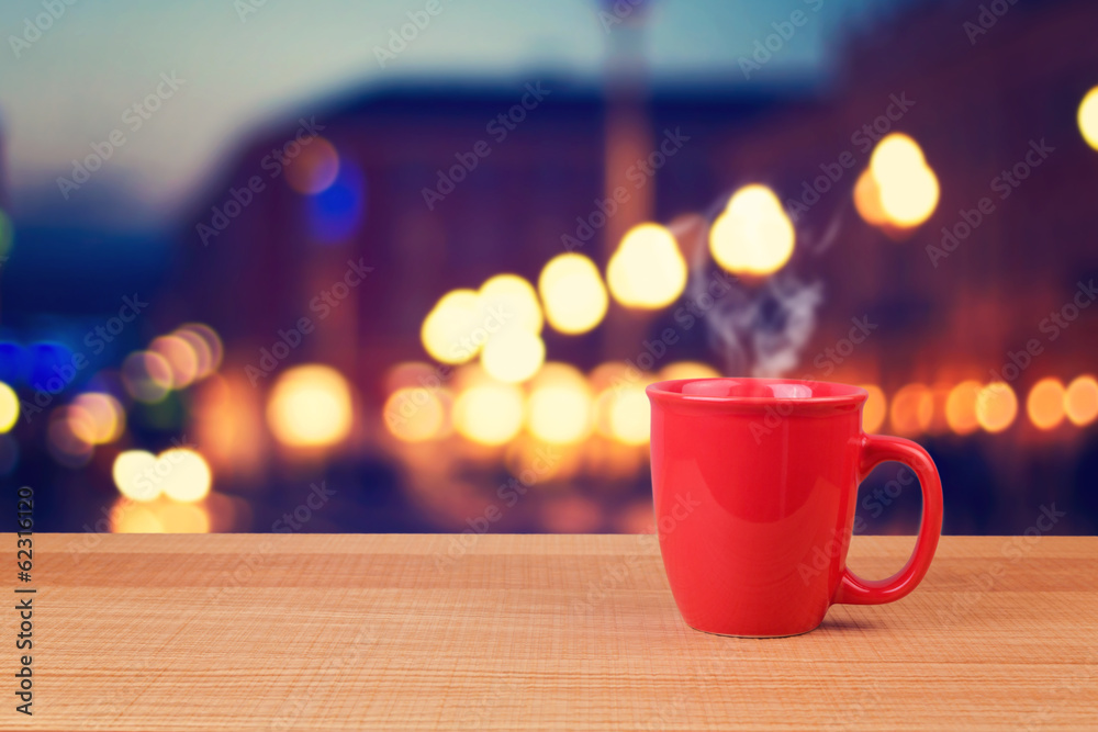 Red cup over city bokeh background Red cup over city bokeh background
