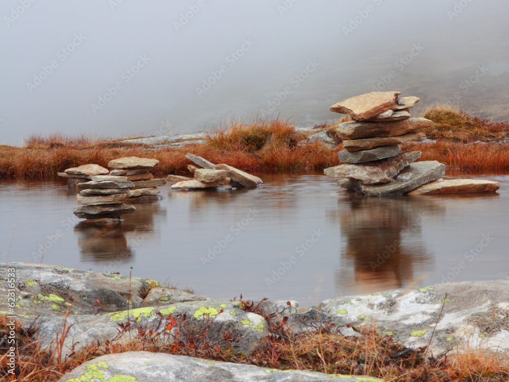 Fototapeta premium Piles of stones in the mountain lake