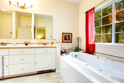 Cozy ivory bathroom with a french window and red curtains
