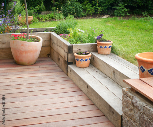 Garden detail with terrace with wooden steps and flowers