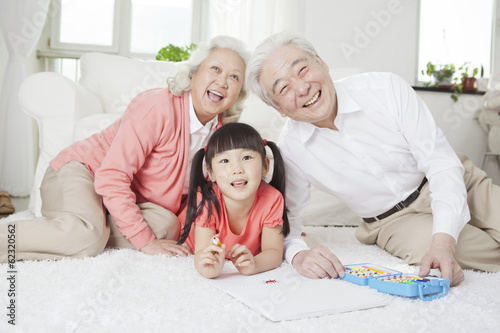 .Senior couple with granddaughter drawing.