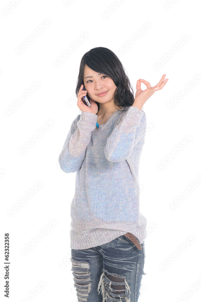 電話しながらOKサインをする女性 電話しながらOKサインをする女性