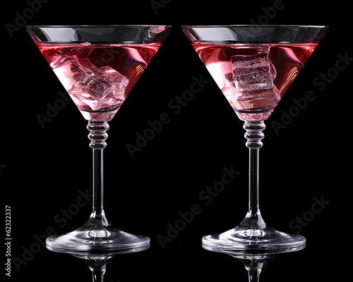 Red cocktail in martini glasses isolated on black