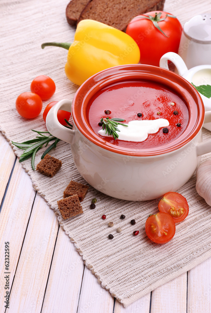 Tasty tomato soup and vegetables on wooden table Tasty tomato soup and vegetables on wooden table