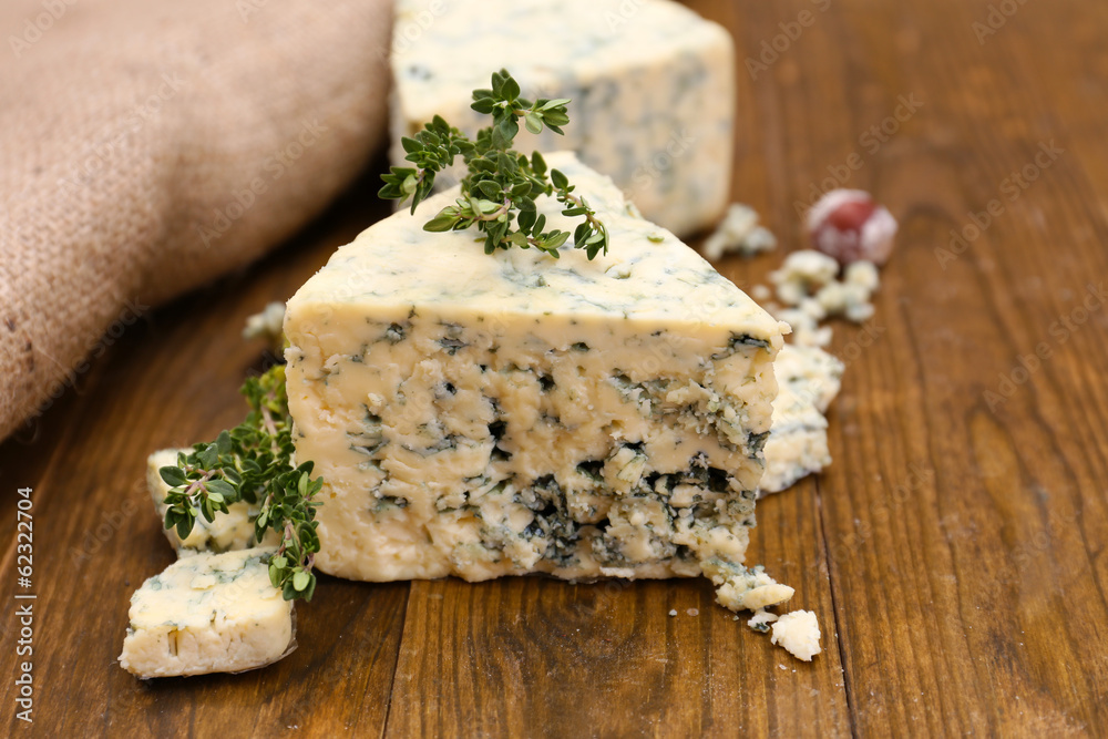 Tasty blue cheese with thyme, on wooden table Tasty blue cheese with thyme, on wooden table