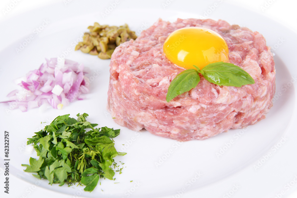 Delicious steak tartare with yolk on plate close-up Delicious steak tartare with yolk on plate close-up