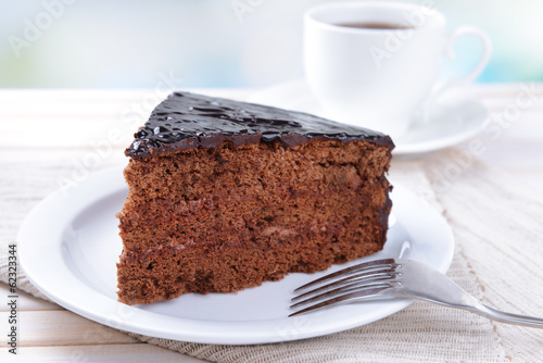 Delicious chocolate cake on plate on table on light background