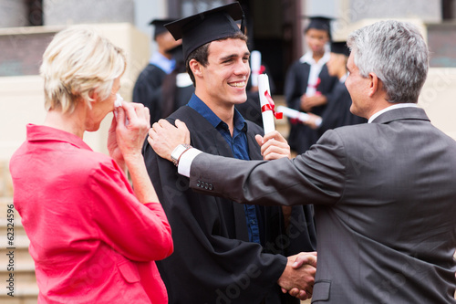 male graduate being congratulated by his father photo