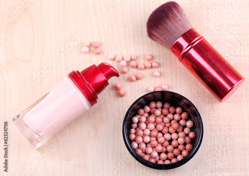 Composition with concealer, powder balls and brush