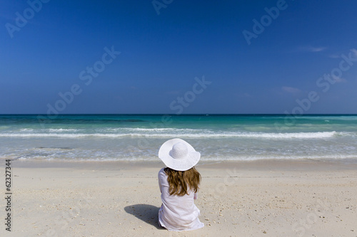 Woman sat up looking at the tropical paradise.