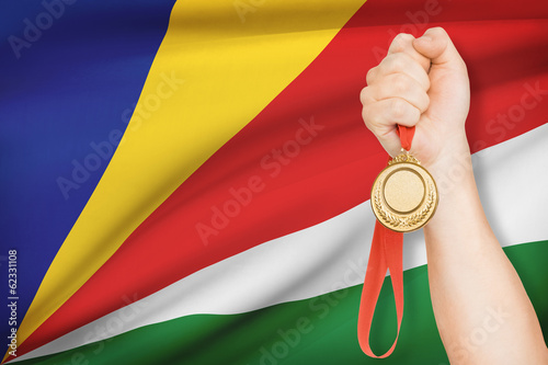 Medal in hand with flag on background - Republic of Seychelles photo