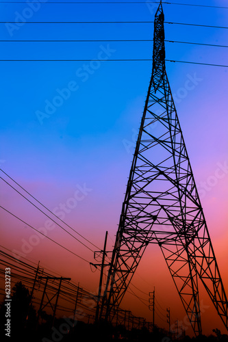 High voltage power pole middle of a cornfield with orange sky
