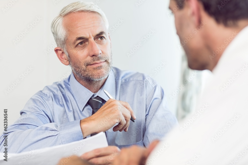 Businessmen doing paperwork at office Businessmen doing paperwork at office