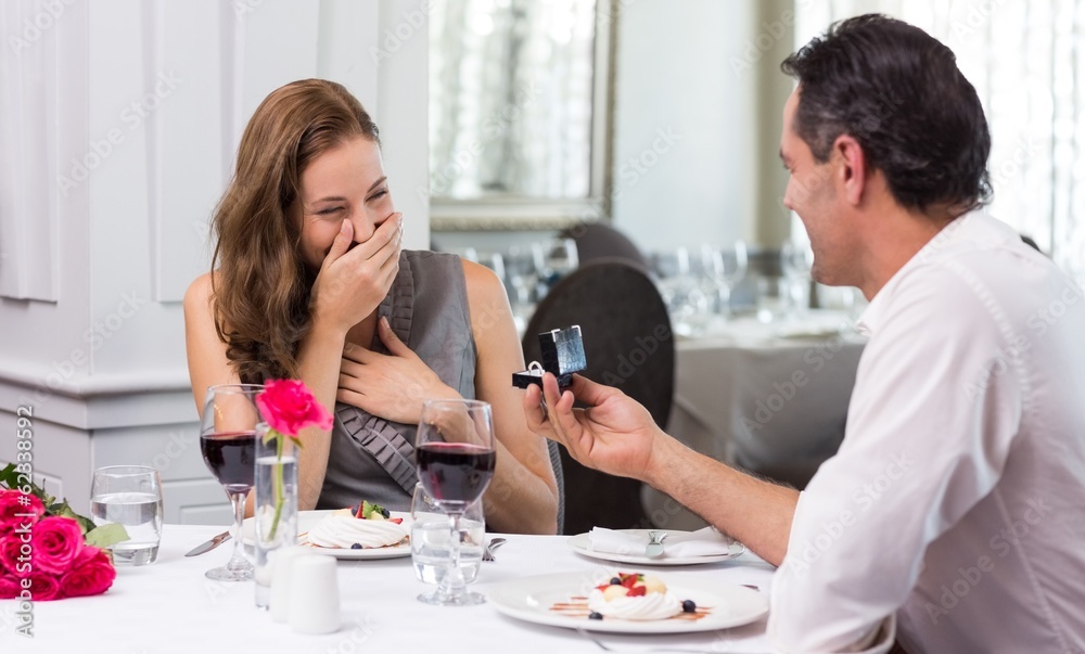 Man proposing a surprised woman in the restaurant Man proposing a surprised woman in the restaurant