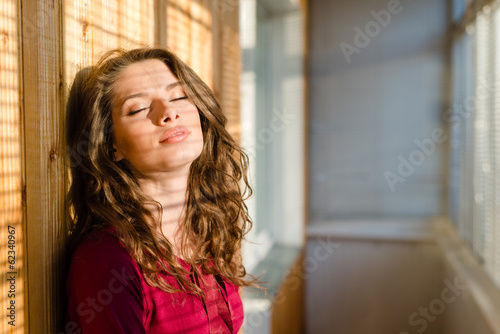 beautiful young woman eyes closed with shadow from window