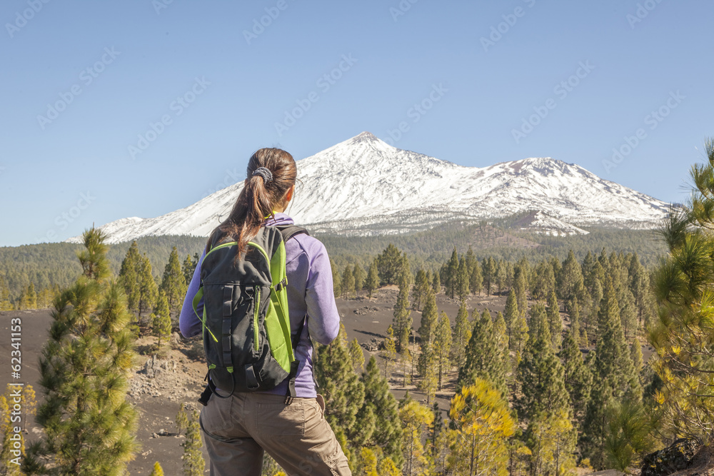 young woman on top of a mountain enjoying the view of volcano te