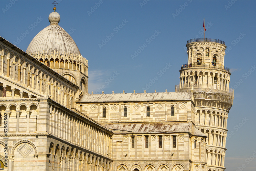 Pisa Cathedral Square with green grass on a meadow and clear blu