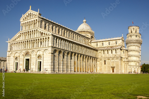 Pisa Cathedral Square with green grass on a meadow and clear blu