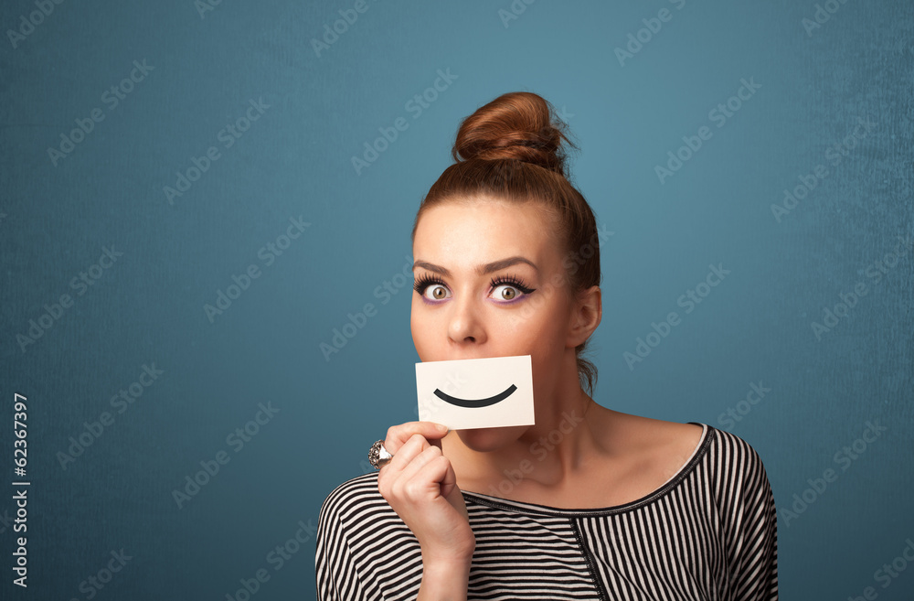 Happy pretty woman holding card with funny smiley Happy pretty woman holding card with funny smiley