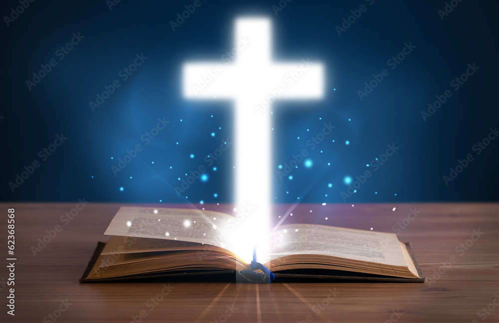 Open holy bible with glowing cross in the middle Open holy bible with glowing cross in the middle