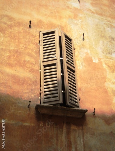 old window on broun wall in Milan, Italy