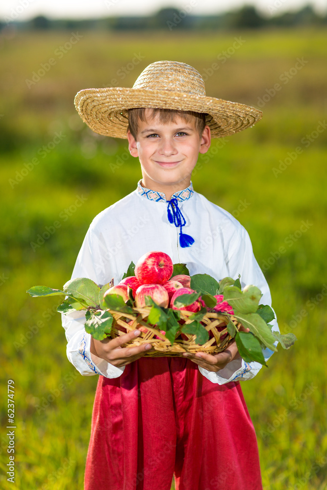 Happy farmer boy hold Organic Apples in Autumn Garden