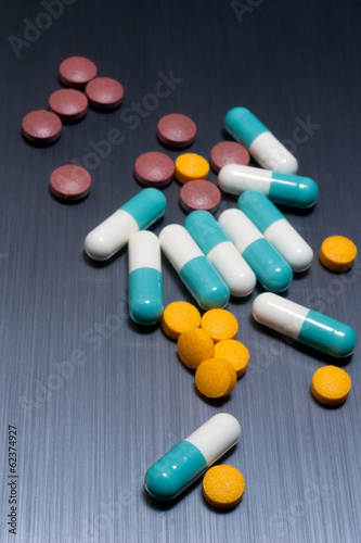 various medical pills on brushed metal background