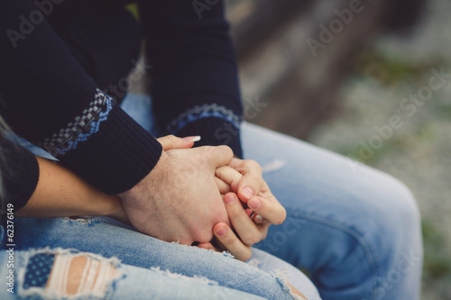 Young couple in love walking in autumn park holding hands