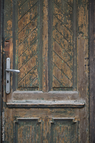 Close-up shot of a weathered keyhole on a wooden door